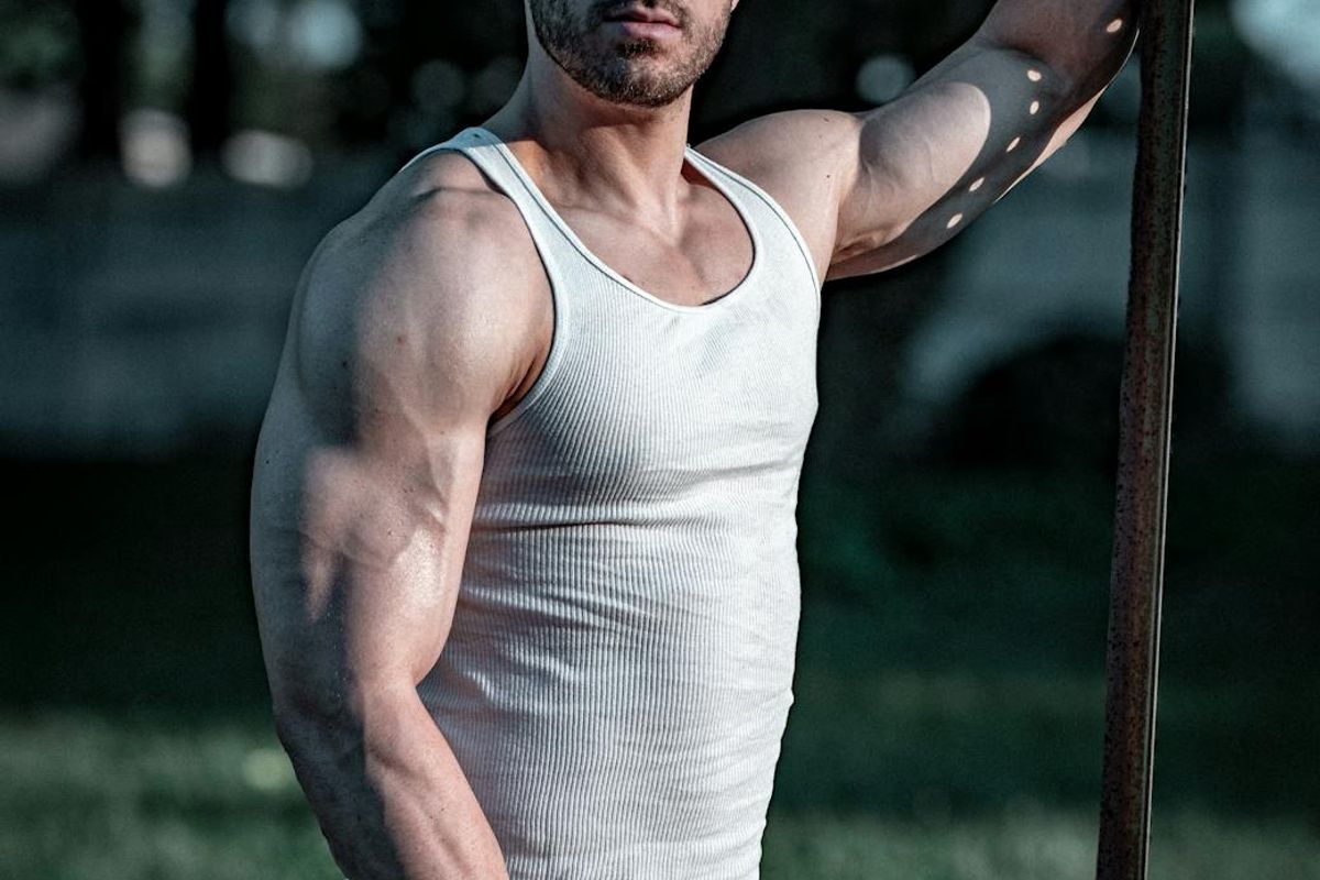 Athletic man in gym environment with dramatic lighting.